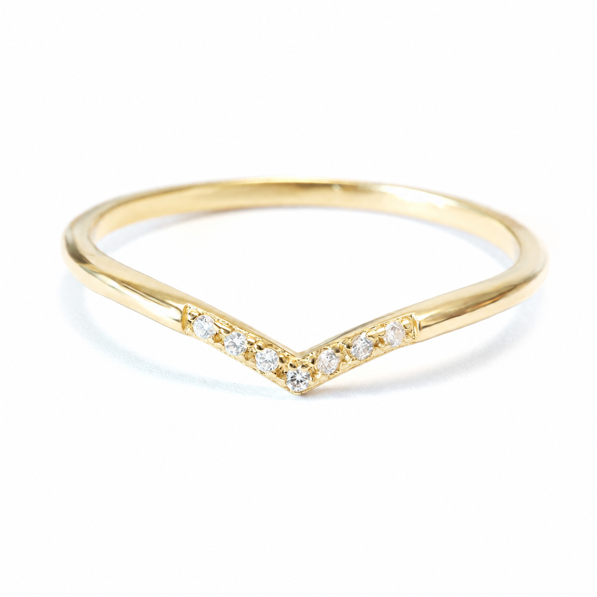 A gold V-shaped ring with a row of small clear stones along the front, photographed on a clean white background.