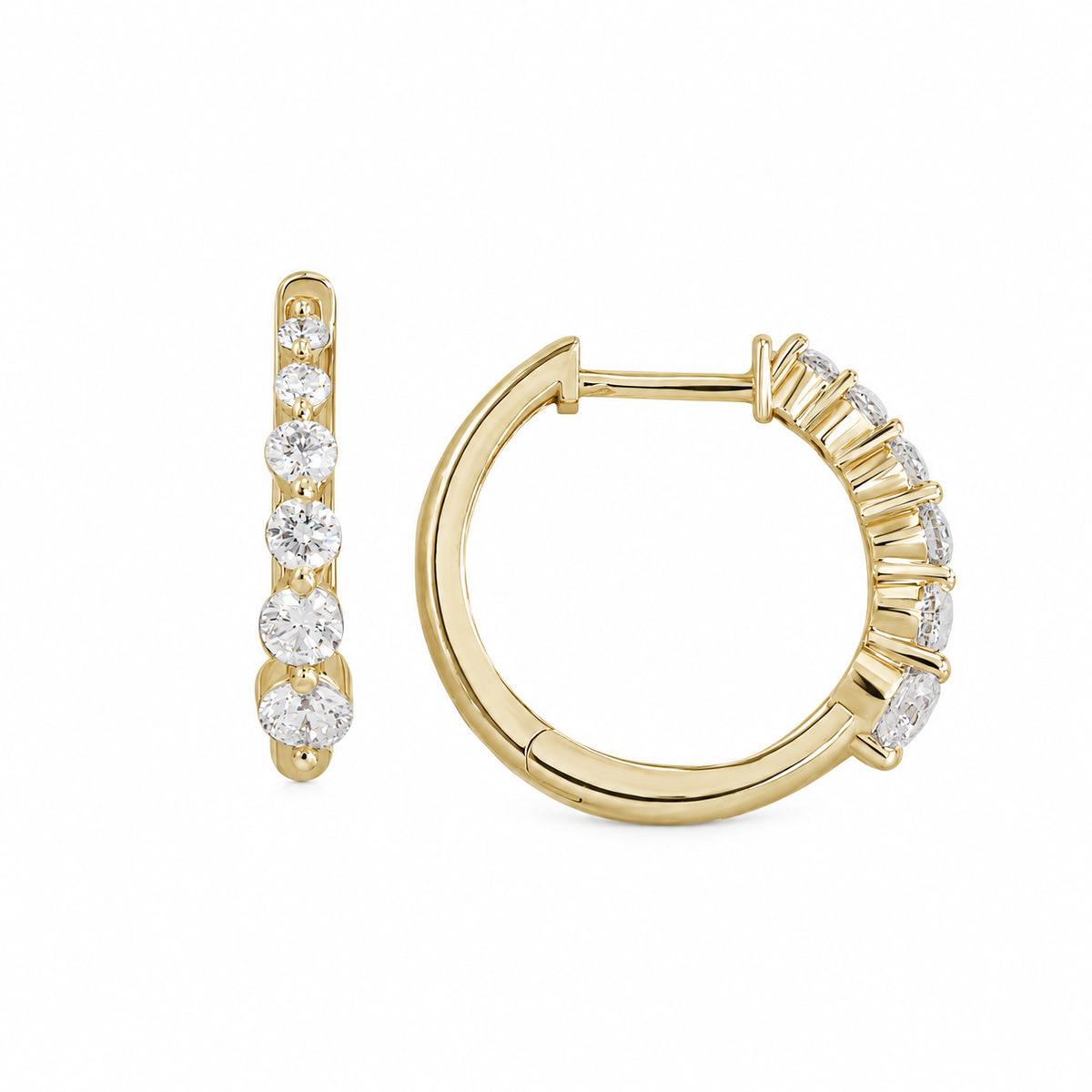 A pair of yellow gold huggie hoop earrings with a channel-set row of round-cut clear gemstones, shown on a plain white background.
