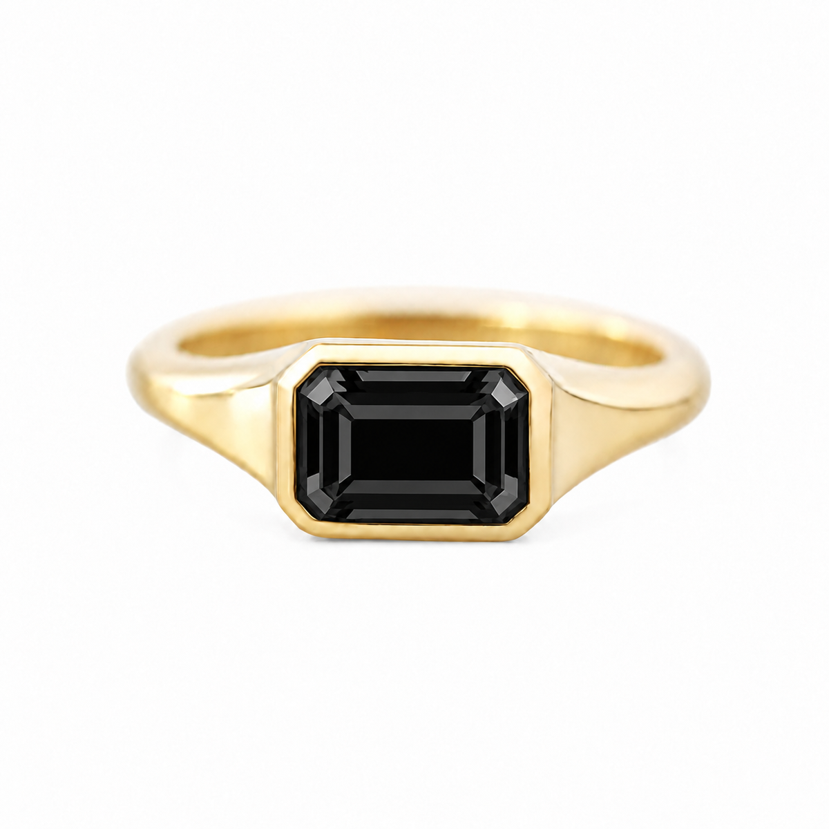 A yellow gold signet ring featuring a rectangular emerald-cut black gemstone, shown against a plain white background.