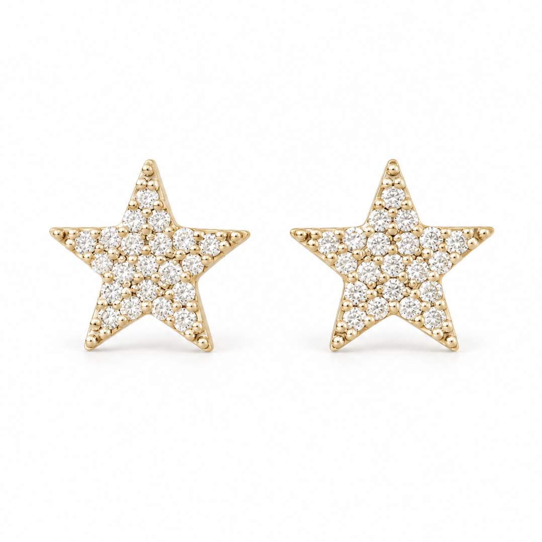 A pair of gold star-shaped stud earrings paved with small clear round stones, set against a plain white background.