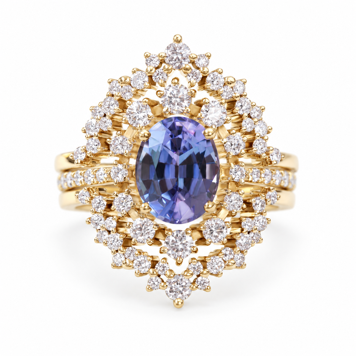 Glory three-ring set with oval tanzanite center and diamonds in soft yellow gold on a white background