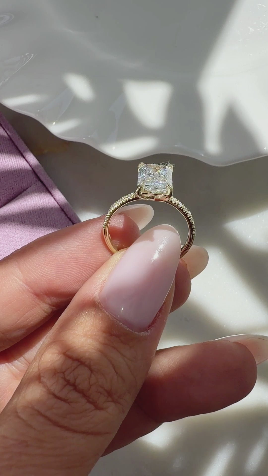 2 ct radiant-cut diamond engagement ring. A yellow gold engagement ring featuring a large rectangular radiant-cut diamond center stone, with a pavé-set diamond band, shown on a clean white background.