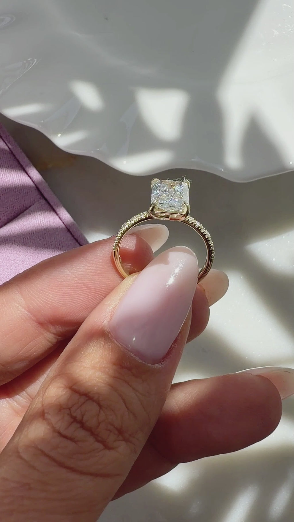 2 ct radiant-cut diamond engagement ring. A yellow gold engagement ring featuring a large rectangular radiant-cut diamond center stone, with a pavé-set diamond band, shown on a clean white background.