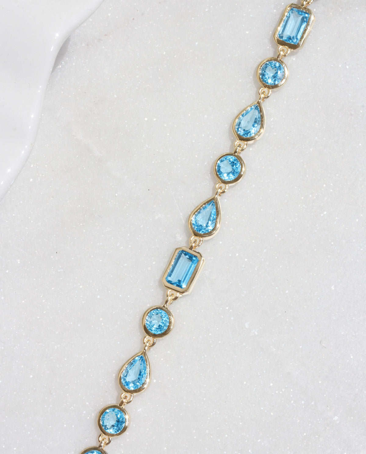 swiss blue topaz multi shape bezel set bracelet yellow gold

