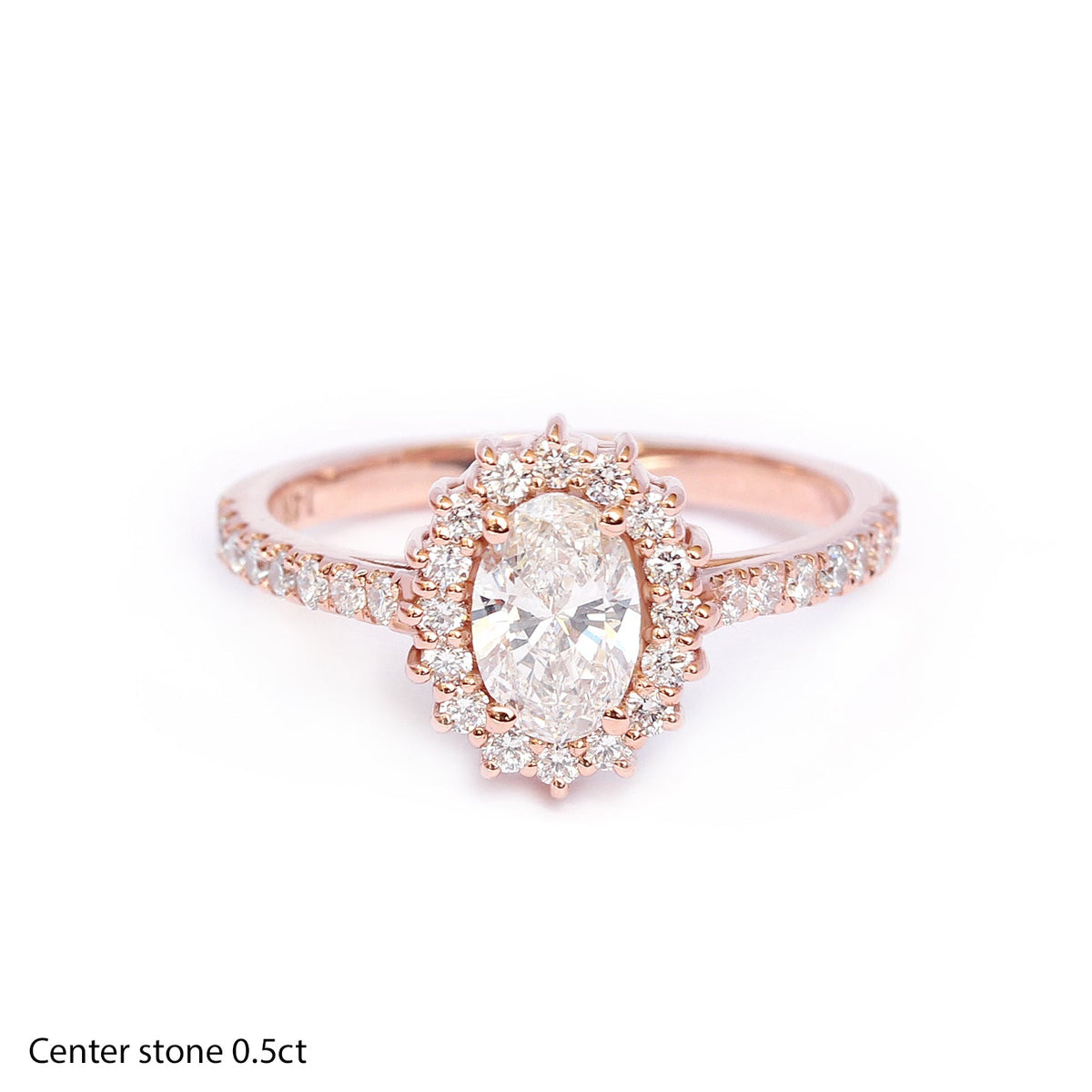 0.50CT oval diamond halo engagement ring with accent stones set in a gold band, the center diamond is surrounded by a halo of smaller diamonds.